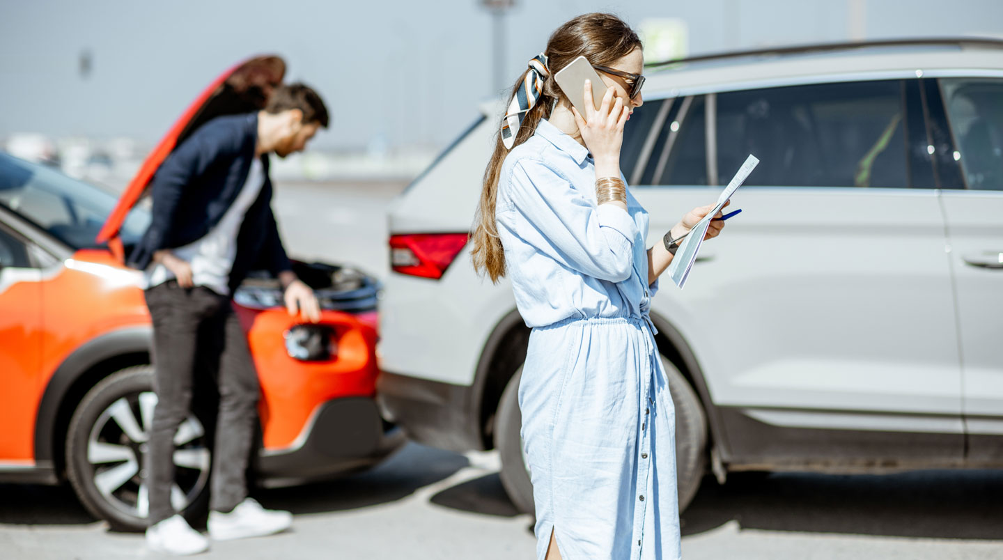Des mains tiennent une carte verte d'assurance automobile à l'intérieur d'un véhicule, avec le volant visible en arrière-plan