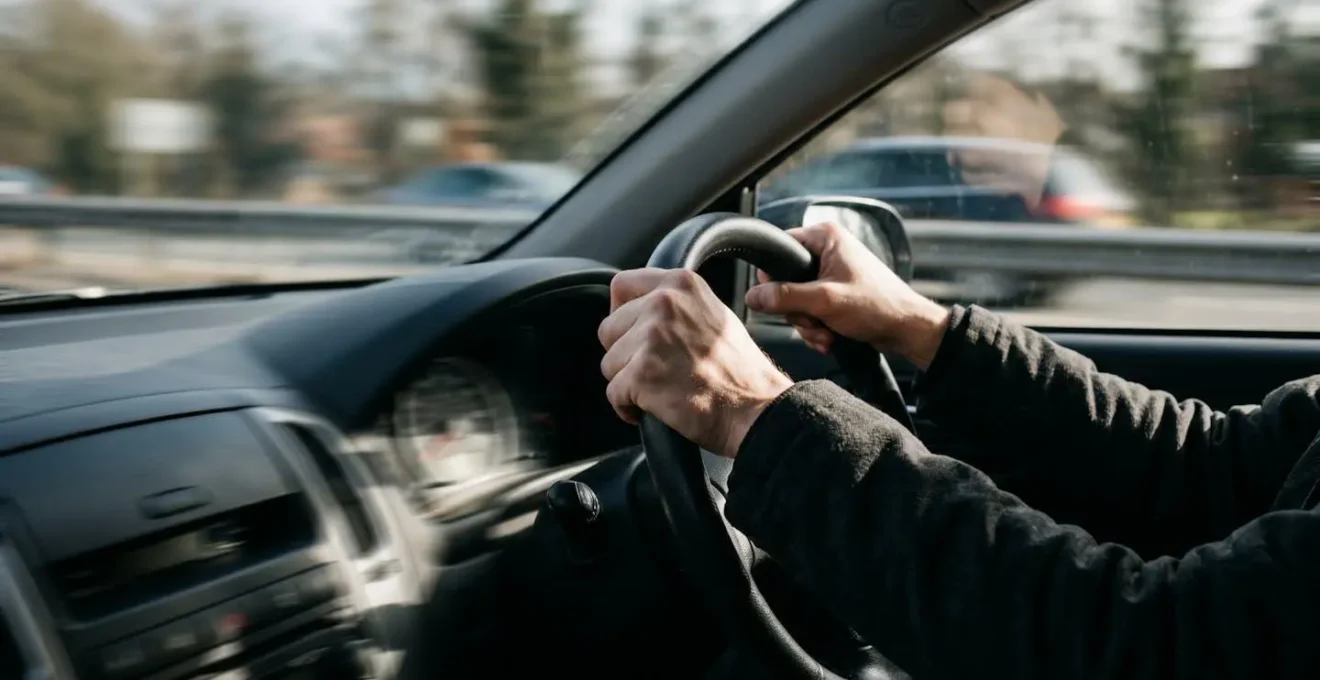 Mains sur volant de voiture en situation de freinage d'urgence avec mouvement flou