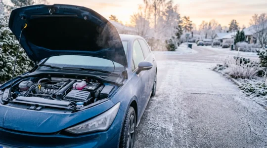 Préparation automobile hivernale avec capot ouvert montrant batterie et liquides